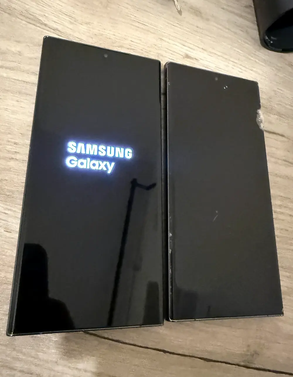 Two Samsung Galaxy S23 Ultra devices pictured while one displays the Samsung startup logo